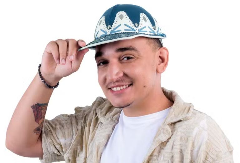 O cantor João Gomes, sorridente e segurando seu característico chapéu de couro, em foto de divulgação.